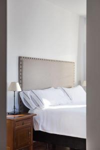 奥尔维拉Hotel Tugasa Sierra y Cal的卧室配有白色的床和木制床头柜。
