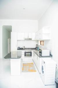 卢萨卡Longhorn Executive Apartments的白色的厨房配有白色橱柜和洗碗机。