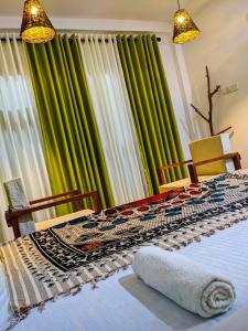 马特勒Light house beach home的一间卧室配有绿色和白色的窗帘和床