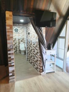 金马仑高原Orkid Chalet的一间带卫生间的浴室和客房内的电视。