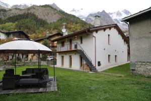 EntrèvesAppartamenti vista Monte Bianco Courmayeur-Entrèves的房屋配有桌椅和遮阳伞