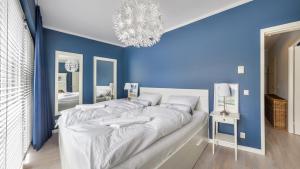 米兹多洛杰Apartamenty Sun & Snow Playa Baltis z sauną的一间蓝色卧室,配有一张大床和吊灯