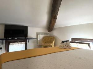 米兰Poste Regie - Milan Guest House的一间卧室配有一张床、电视和椅子