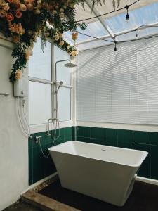 南府Ceraclay Home的带浴缸的浴室和窗户