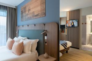 库尔布瓦馨乐庭巴黎德芬斯酒店的一间卧室配有一张带枕头的大床