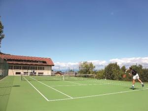 吕格兰Duplex dans Chalet entre Lac et Montagne - Vue Lac的在网球场打网球的男人
