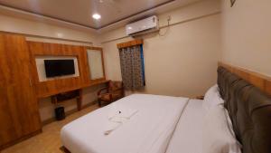 孟买HOTEL RIGGA INN KOKILABEN DHIRUBHAI AMBANI Hospital的一间带床和电视的小卧室