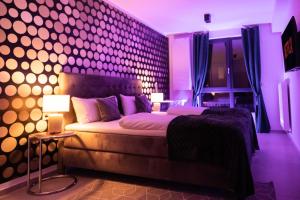 纽伦堡THE Penthouse at Eco Smart Apartments的卧室配有一张带紫色灯的墙壁床。