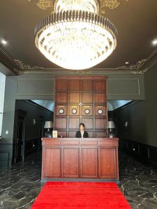 奇姆肯特WIND HOTEL的站在一张桌子上,在一间铺有红地毯的房间