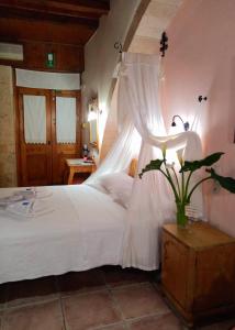干尼亚帕拉佐迪皮特罗公寓酒店的一间卧室配有一张带天蓬的白色床