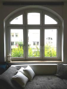 多特蒙德Get-your-flat - Tiny Flat in Gründerzeithaus, super sweet, Kreuzviertel - 50 m2 EG Haustier auf Anfrage的配有床和枕头的大窗户