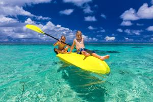 Nanuya LailaiBay of Plenty Nature Lodge的两个孩子坐在海上的黄色皮艇上