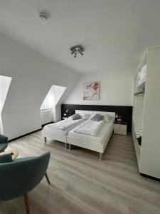 班贝格花园城市公寓式酒店的白色卧室配有床和椅子