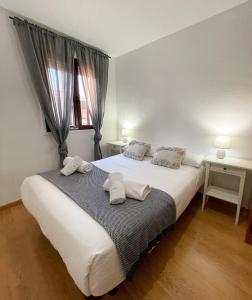 萨拉戈萨AZ El Balcón de Luna的卧室配有带毛巾的大型白色床
