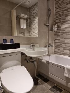 首尔库雷塔克索因萨东酒店的浴室配有卫生间、盥洗盆和浴缸。