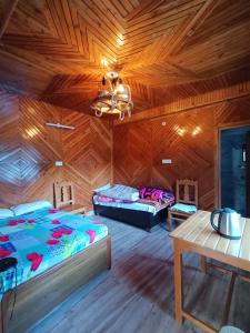 乌德尔格希Hill dew homestay的卧室设有木制天花板、一张床和一张桌子