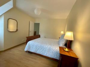 贝叶Le Mulberry的一间卧室配有一张床、一盏灯和一面镜子