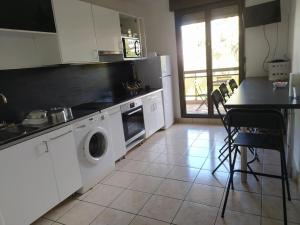 里昂Chambres dans guest house à Lyon-GARE Part-Dieu的厨房配有洗衣机、烘干机和桌子