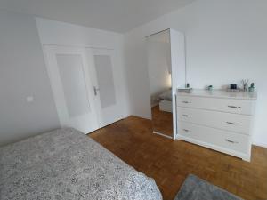 里昂Chambres dans guest house à Lyon-GARE Part-Dieu的一间白色卧室,配有一张床和一个梳妆台