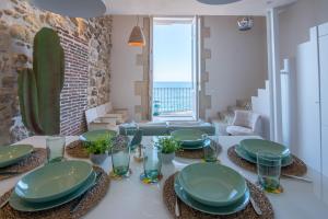 锡拉库扎Veronique by Dimore in Sicily的一间用餐室,配有一张带绿盘的桌子