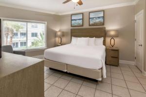 奥兰治比奇Palm Beach Resort Orange Beach a Ramada by Wyndham的卧室设有一张白色大床和一扇窗户。
