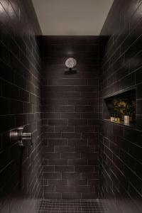 亚特兰大Thompson Atlanta - Buckhead, by Hyatt的黑色浴室设有黑色瓷砖淋浴。