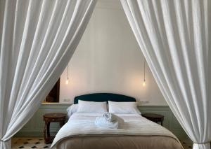 欧坦Le Cocand的卧室配有一张带白色窗帘的大床