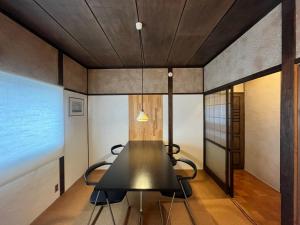 长崎AKUNOURA HUIS的一间用餐室,配有黑色的桌子和椅子