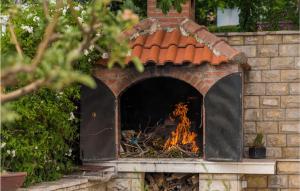 卡什泰拉Beautiful Home In Kastel Sucurac With House Sea View的砖砌壁炉,壁炉里放着火