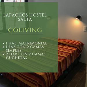 萨尔塔Lapacho Hostel Salta Coliving的一间卧室,配有一张带标志的床