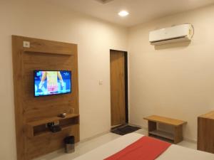 艾哈迈达巴德Hotel Maan Palace的一间房间,配有一张床和墙上的电视