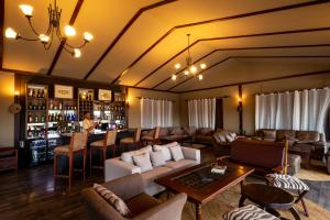 塞伦盖蒂国家公园Serengeti Sametu Camp的带沙发的大型客厅和酒吧