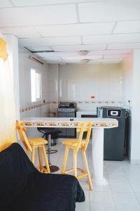 La BoquillaNativo Kite House的一间厨房,里面配有一张桌子和两张凳子