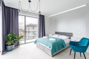 米兹多洛杰Balticus Apartamenty Standard Promenada Gwiazd 14的一间卧室配有一张床和一张蓝色椅子