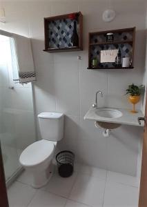 伊比拉奎拉Recanto Casa SOL的白色的浴室设有卫生间和水槽。