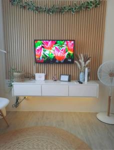 卡兰巴Amaia Steps Nuvali fully furnished unit with swimming pool view near Carmelray Pitland的坐在白色橱柜顶上的电视