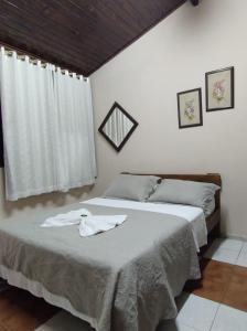 布罗塔斯Pousada Boa Vista的一间卧室配有一张带白色床单的床和窗户。