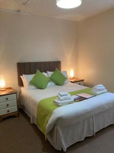 韦茅斯梅菲尔旅馆的一间卧室配有一张带绿色枕头的大床
