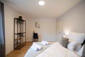 富尔达Peter Apartments - Premium Wohnung I 95qm I 3 Schlafzimmer I großes Bad I Küche I Wohnzimmer I TV的一间卧室配有一张带两个枕头的床