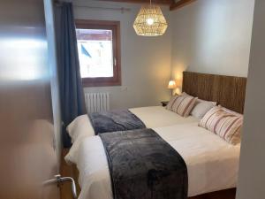 福米加尔Chalet Los Ibones - Lodge Formigal的卧室设有一张白色大床和一扇窗户。