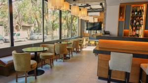 富内斯Ferrol Apart Hotel的一间带桌椅的餐厅和一间酒吧