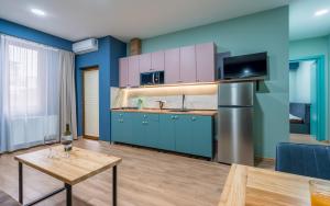 第比利斯Hotel City Lights - Tbilisi的厨房配有蓝色橱柜和木桌
