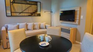 富内斯Ferrol Apart Hotel的客厅配有桌子和沙发