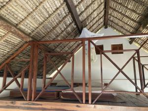 MangalimasoMaison bord de mer的茅草屋顶的房间里一张床位