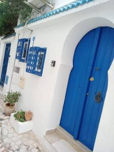 西迪·布·赛义德Élégante Maison ' in Sidi Bou Saïd confartable, Spacieux, Central的白色建筑一侧的蓝色门
