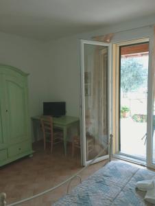 福洛尼卡Agriturismo dal Pastore的客房设有一张桌子和一张带玻璃门的桌子。