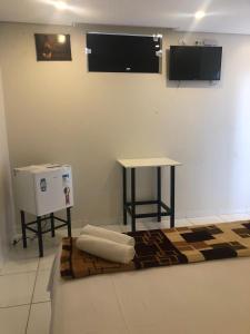 圣代佩德罗HOTEL E POUSADA ISIS的一间设有桌子、电视和地毯的房间