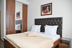 波德戈里察Motel Celebic的一间卧室配有一张大床和黑色床头板