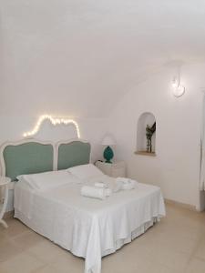 奥特朗托帕拉佐德摩利酒店的卧室配有白色的床和2条毛巾