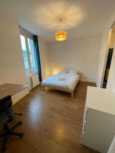 普瓦捷LE PERCHOIR-POITIERS-LaConciergerie的一间卧室配有一张床、一张桌子和一把椅子